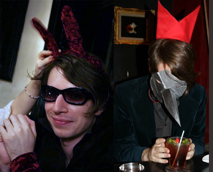 Black and white rabbit from Alice in Wonderland, bunny ears on Goth boy, Gothic bunny costume, sunglasses and velvet vintage men's jacket, Eyes Wide Shut mask, napkin crown on head, beak in glass of fruit juice
